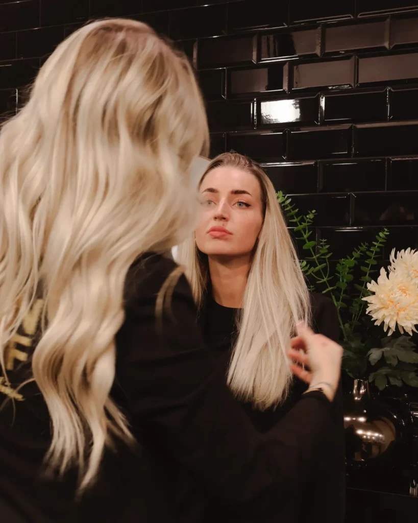 Klant met lang blond haar bij de spiegel in Salon TOF
